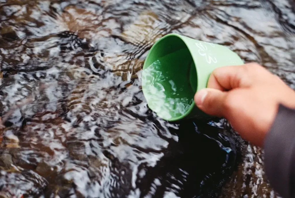 scooping water with a green cup